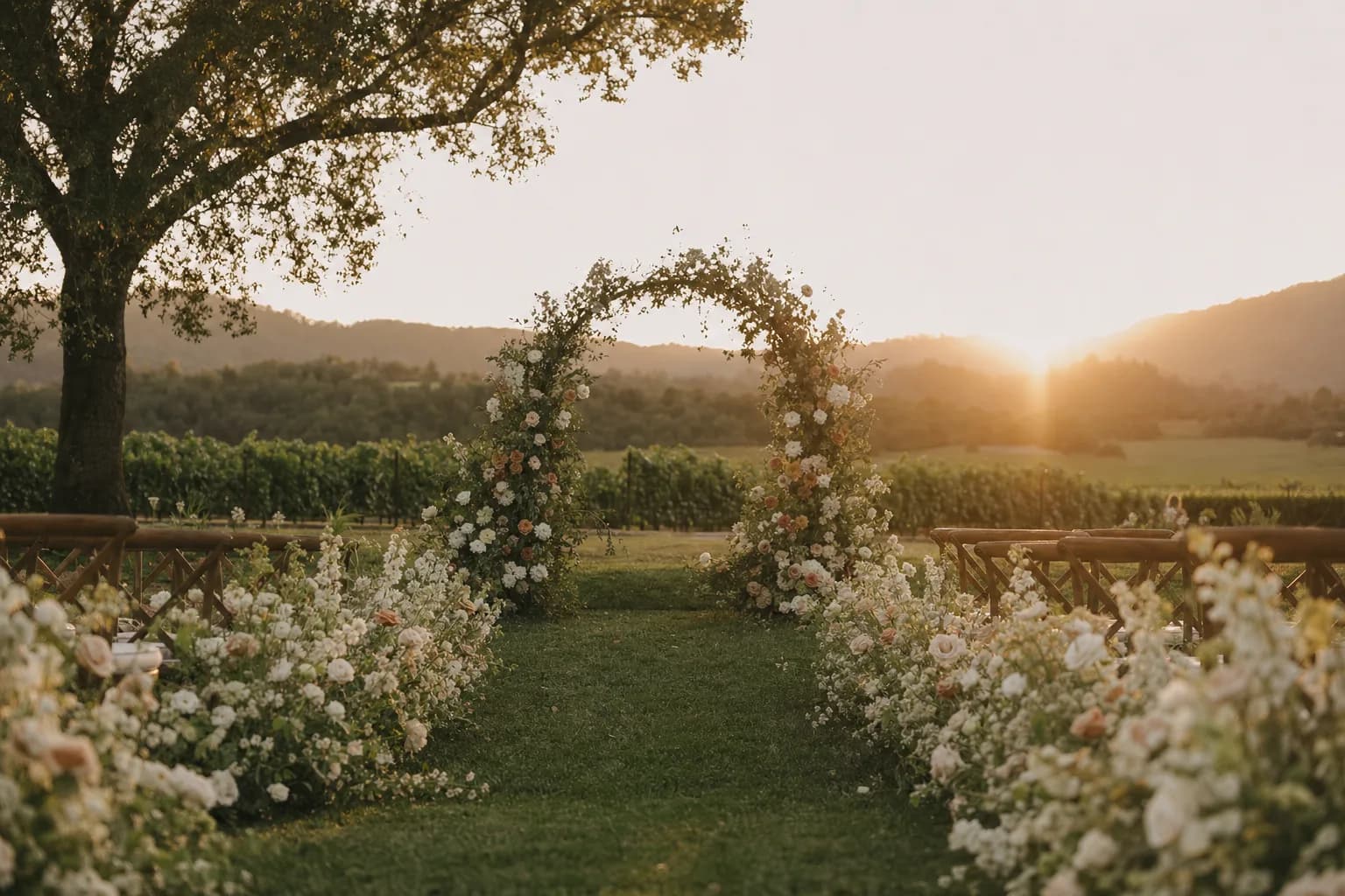 A floral ceremony arch at golden hour in a vineyard